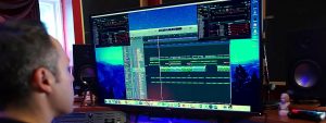 Tom Salta looking at a computer screen working on a song
