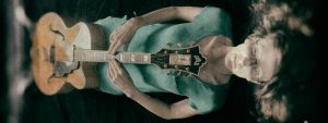 Mary Halvorson laying flat with Guild guitar on top