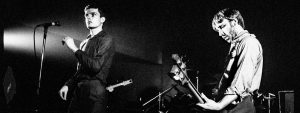 Ian Curtis and Peter Hook performing on stage